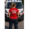 Soccorritore donna con maglietta 112 davanti a un'ambulanza